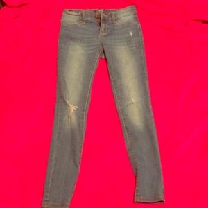 Blue jeans that are ripped (made with rips)